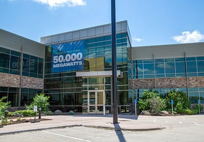 Corporate headquarters building displaying 50,000 megawatts celebration banner