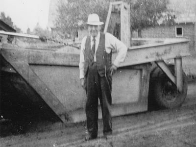 B&W Photo of early Blattner worker in front of machinery
